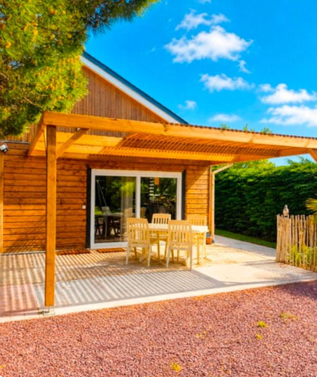 a wooden patio with a table and chairs at Gîte Le Chemin du Cap in Plévenon