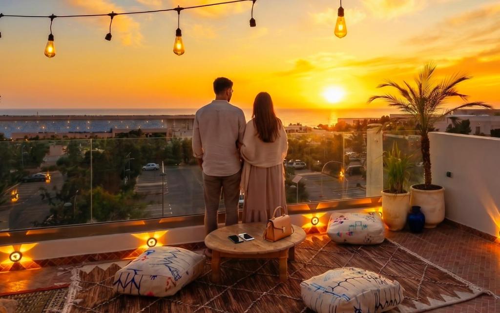 a couple standing on a balcony watching the sunset at White Majorelle Horizon in Tamraght Ouzdar