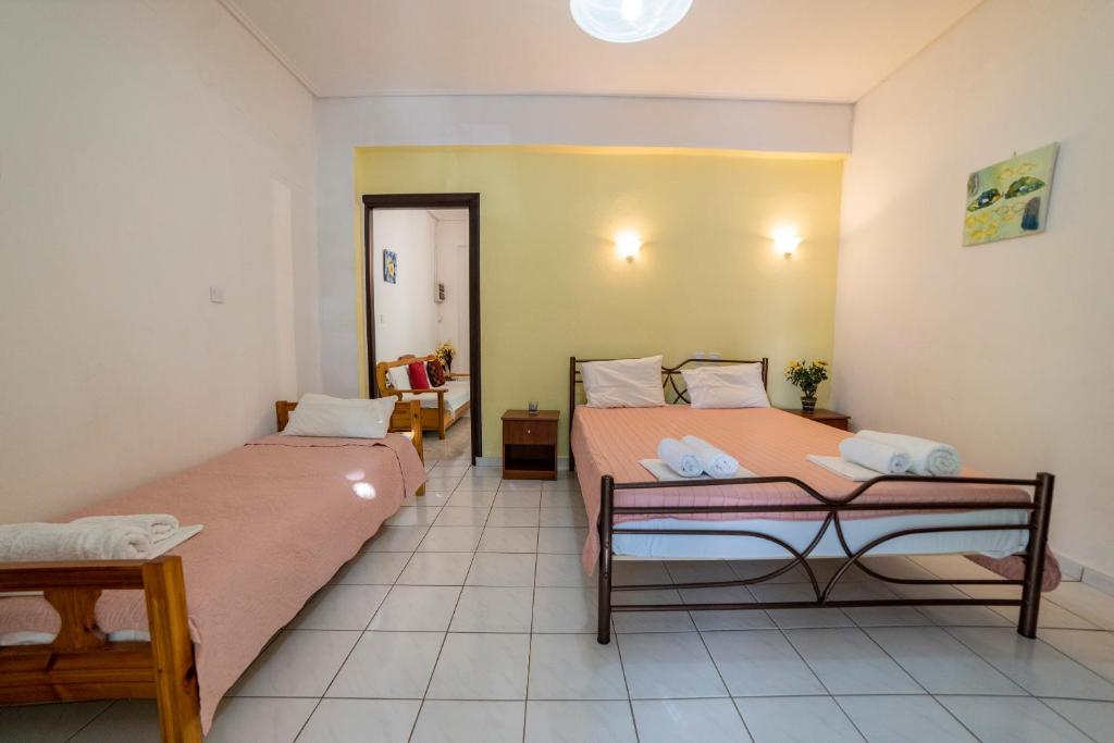 a room with two beds and a table at Apartment's Eleni in Kamena Vourla
