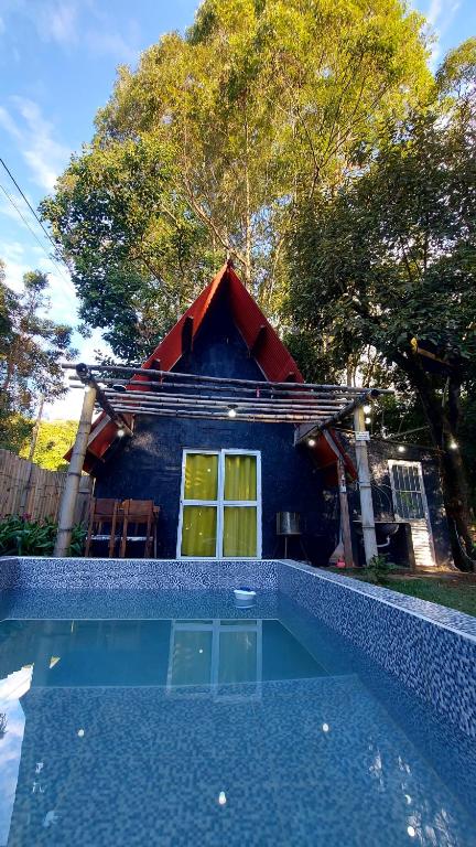 a small house with a swimming pool in front of a house at Chale mundo da Lua 2 in Piedade
