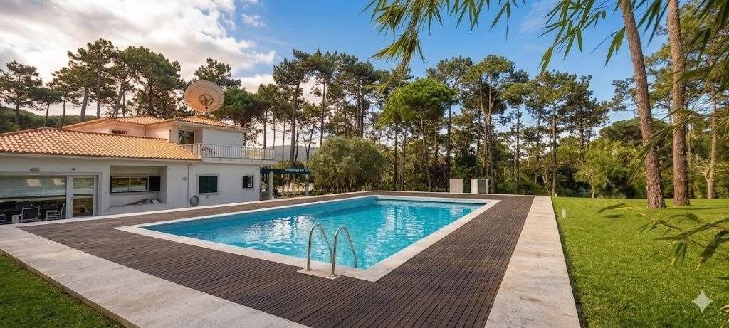 a swimming pool in front of a house at Villa Colares in Sintra