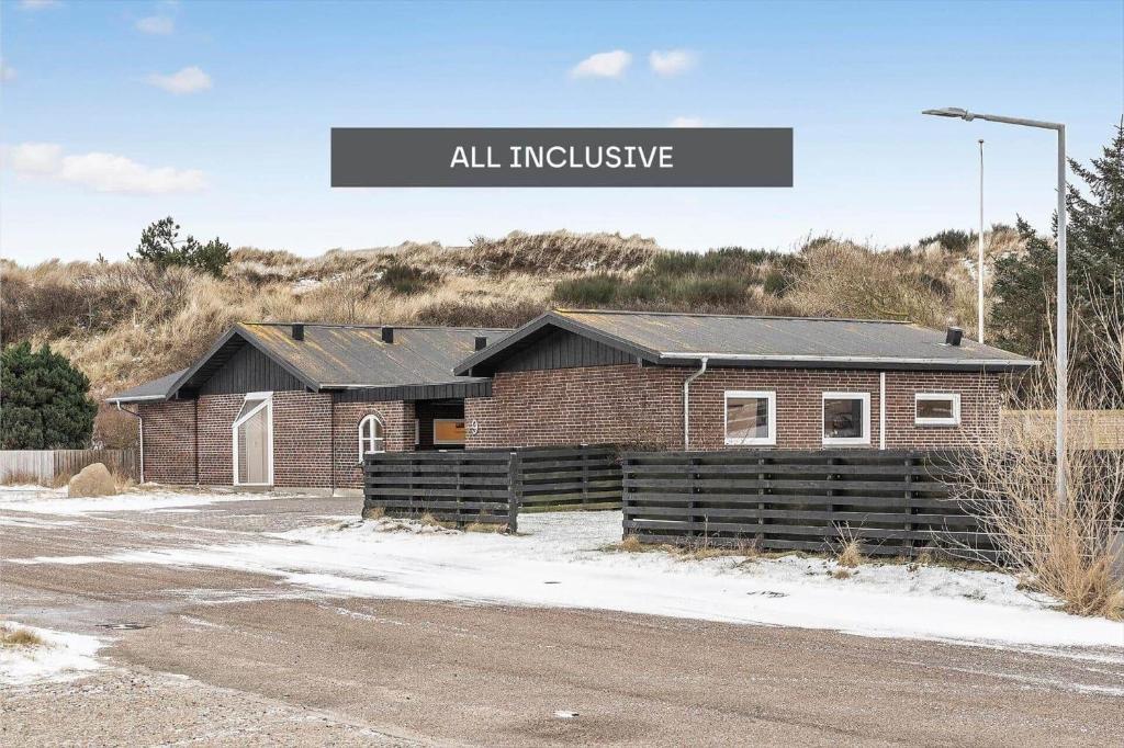a brick building with a sign that reads all inclusive at 8848-Hvide-Sande-Numitvej-9 in Hvide Sande