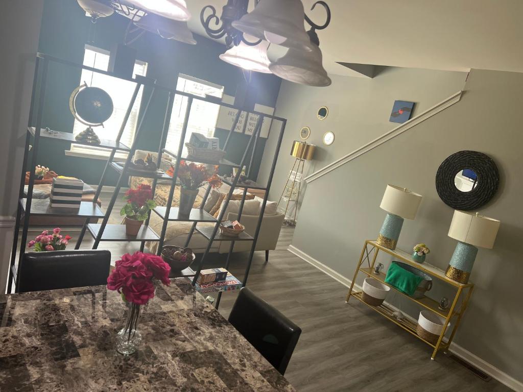 a room with a table with a vase of flowers on it at Spacious 3 bedroom 3 bathroom cozy home with patio 15 mins away from ATL in Decatur