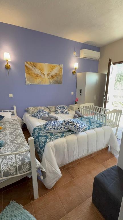 two beds in a room with purple walls at Angelparadise village stefani in Stefáni