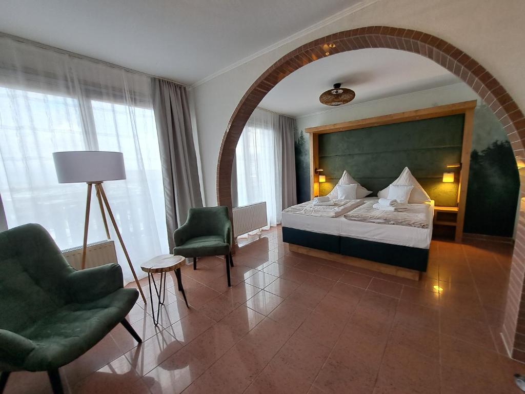 ein Hotelzimmer mit einem Bett und zwei Stühlen in der Unterkunft Hotel Wernerwald - Restaurant, Wellness & Events in Cuxhaven