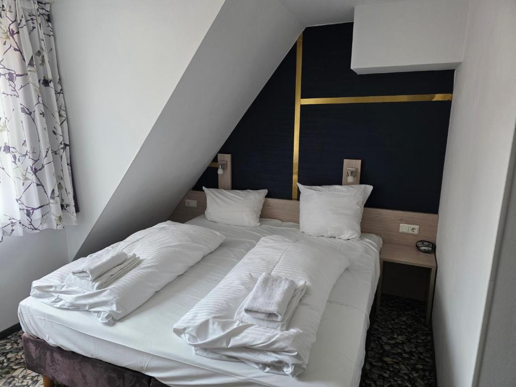 a bedroom with a bed with white sheets and pillows at Die Remise Copenhagen RE-16 in Stolpe auf Usedom