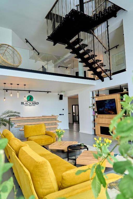 a living room with a yellow couch and a table at BlackBird Hub in Arad