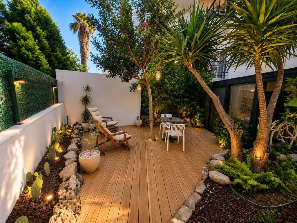 a garden with palm trees and a wooden deck at Alex Suites Lara in Antalya