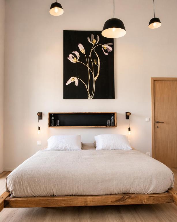 a bedroom with a bed and a painting on the wall at Hors-Champs in Gembloux