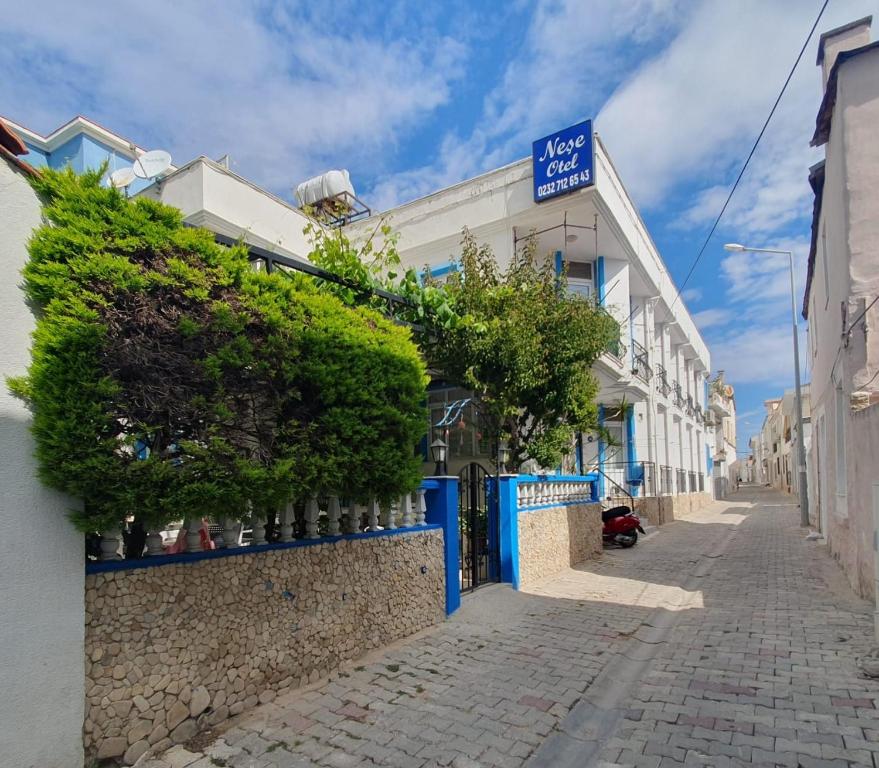 a street with a blue fence and a building at Nese Otel in Çeşme