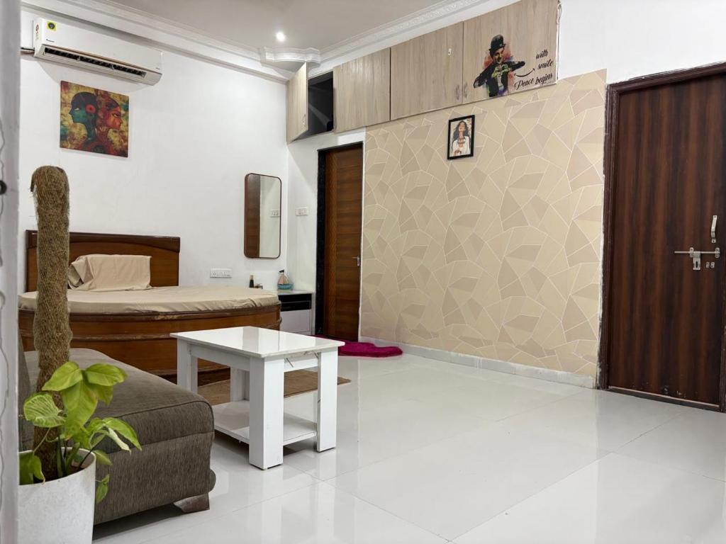 a living room with a bed and a couch and a table at Kesarionstay in Indore
