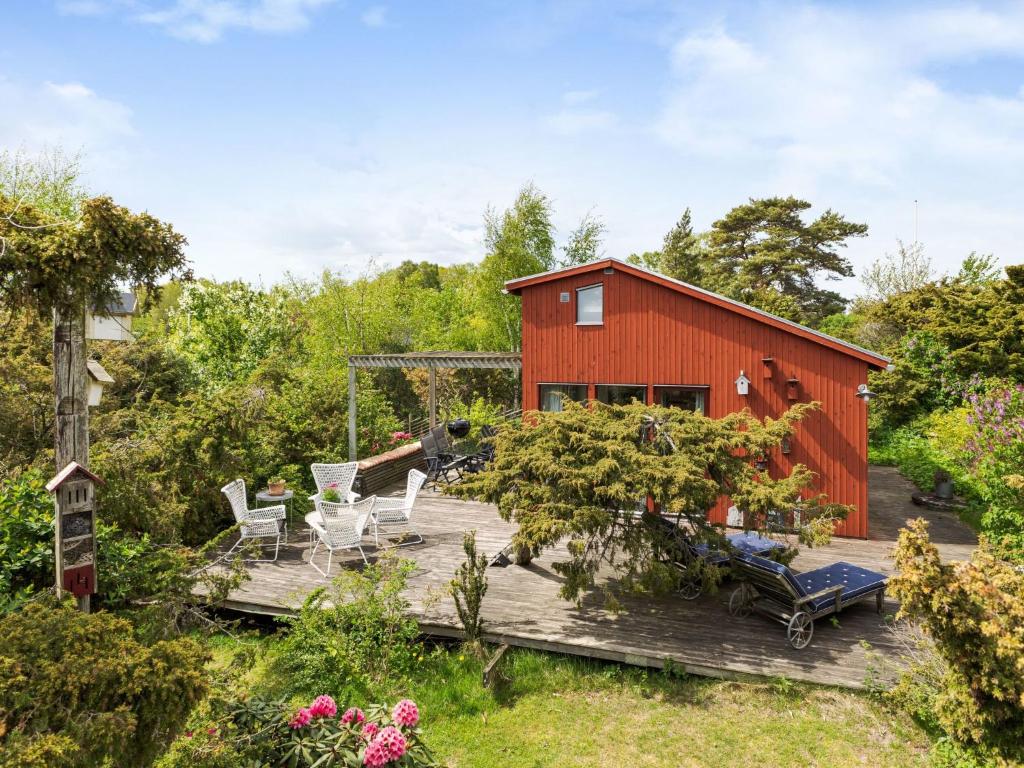 a red barn with chairs and a deck at Holiday Home Ringenäs by Interhome in Halmstad