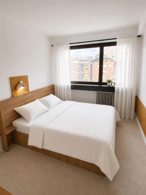 a bedroom with a large bed and a window at The Square Central Prishtina in Prishtinë