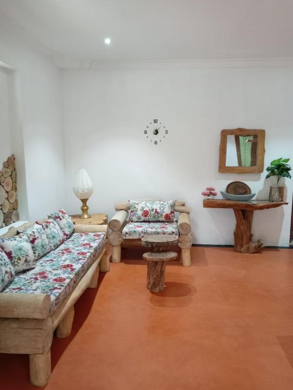 a living room with two couches and a table at The Wood Cottage in Elkaduwa