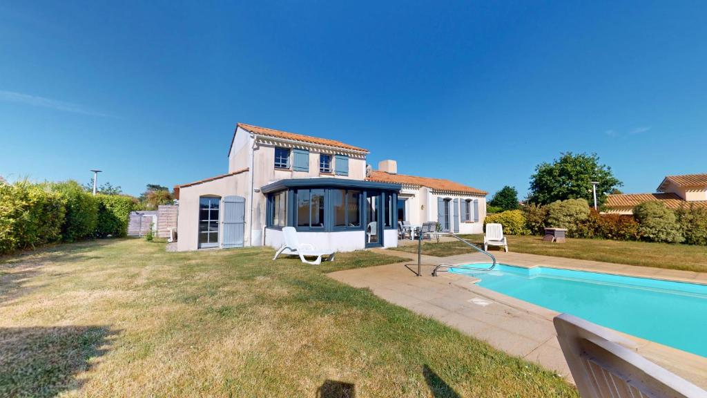 a villa with a swimming pool and a house at Villa BlueGreen in Coëx