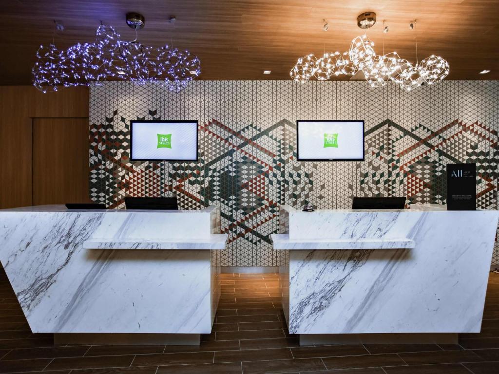 a lobby with marble counters and a wall with a mosaic at ibis Styles Kota Bharu in Kota Bharu