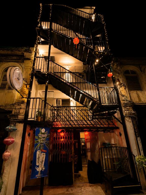 a building with a spiral staircase next to a building with a clock at Astrid Lofts in Ipoh