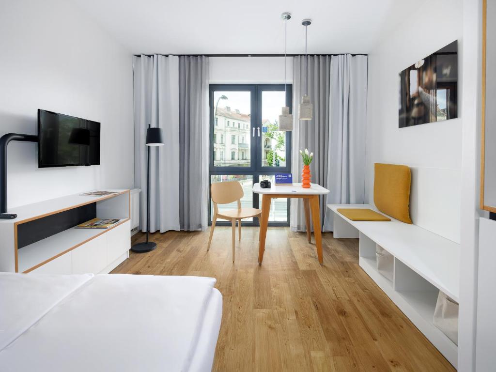 a bedroom with a bed and a desk with a table at smartments Berlin Karlshorst in Berlin