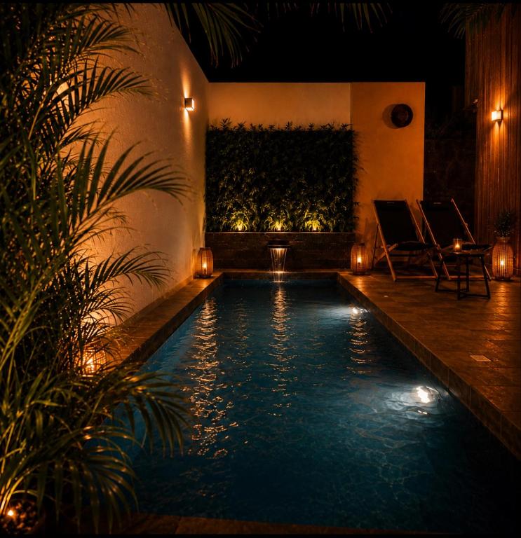 a swimming pool in a house at night with lights at Au temps des pêcheurs - Terre Sainte - PISCINE CHAUFFÉE in Saint-Pierre