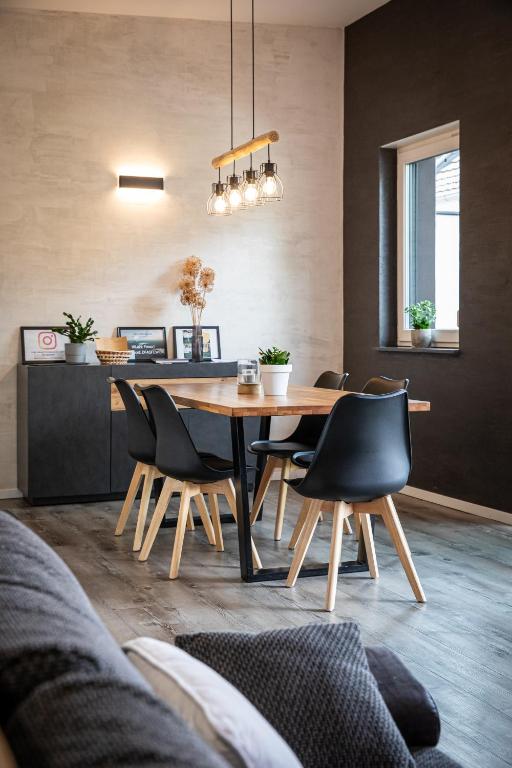 a dining room with a wooden table and chairs at Fewo River, Stilvolles Ferienhaus für Familien großer Garten, Spielplatz, Sauna & Badefass in Wendisch Rietz