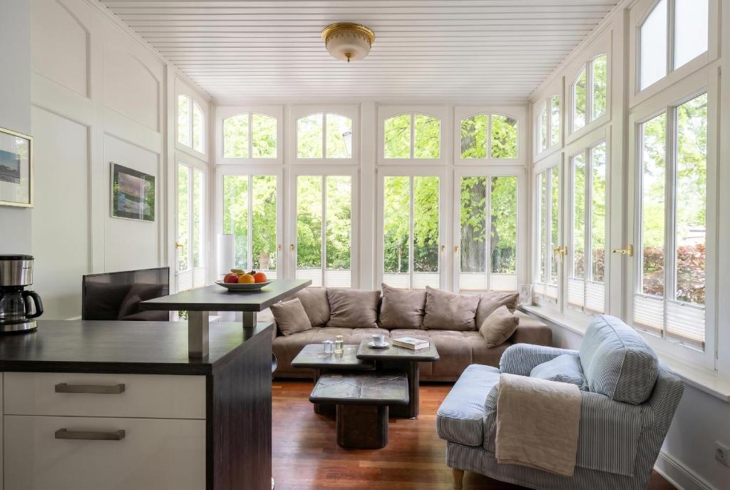 a living room with a couch and a table at Kapitänsapartment in der VILLA KAETHE am Kurpark - moderne & stilvolle 65qm Ferienwohnung nahe Strand in Warnemünde