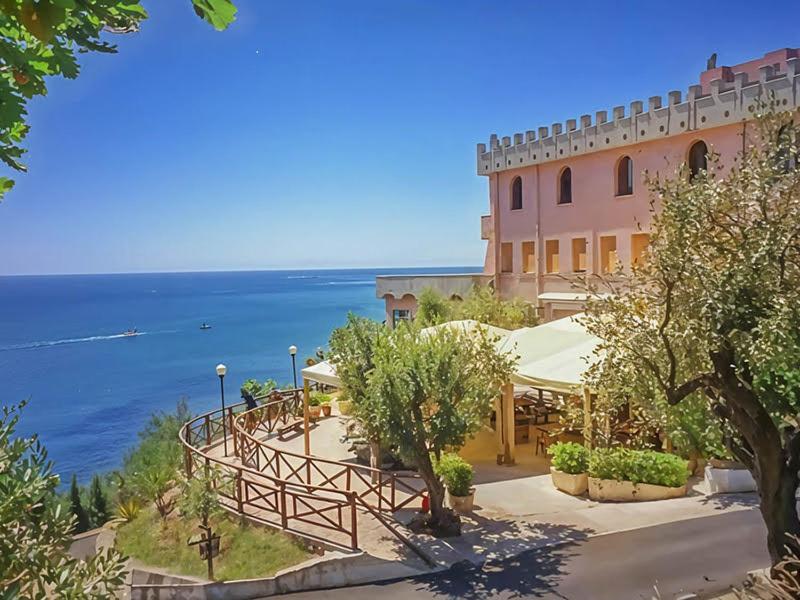 a view of a building with the ocean in the background at Villaggio Club Tortorella in Marina di Casalvelino