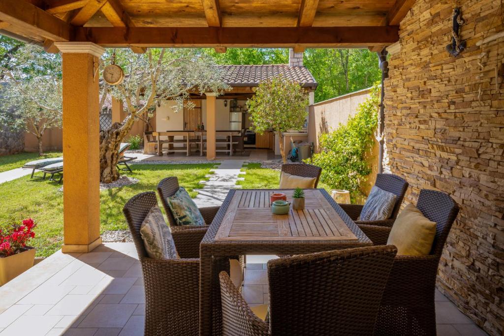 a patio with a table and chairs on a patio at Apartman Sara s vrtom in Vantačići