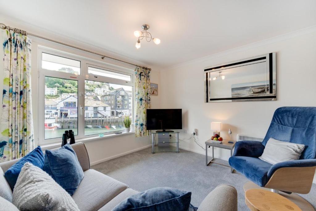 a living room with a blue couch and a tv at 1 Bed in West Looe oc-1west in Looe