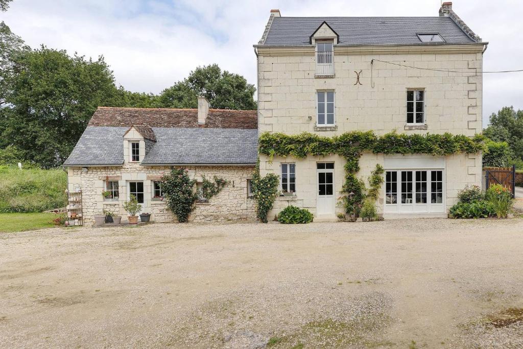 an old stone house with ivy growing on it at Le Bourg Joly in Rigny-Ussé