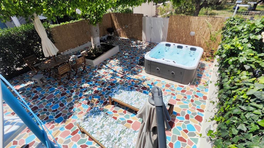 a pool with a hot tub on a patio at Mami in Malia