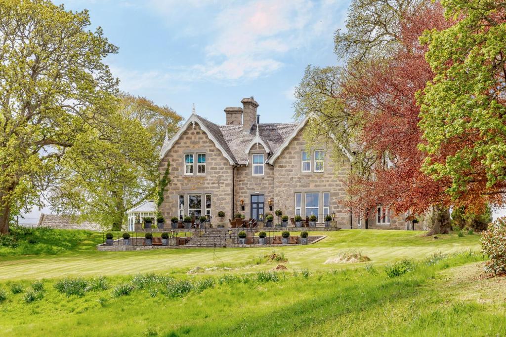 an exterior view of a large stone house at Muckrach Country House in Skye of Curr