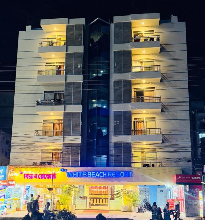 a tall apartment building with a white facade at The White Beach Resort in Cox's Bazar