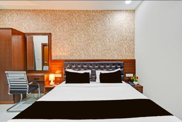 a bedroom with a large bed and a mirror at Hotel GREEN LEAF in Hyderabad