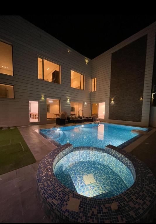 a large swimming pool in front of a building at Villa with private Pool A in Al Khīrān
