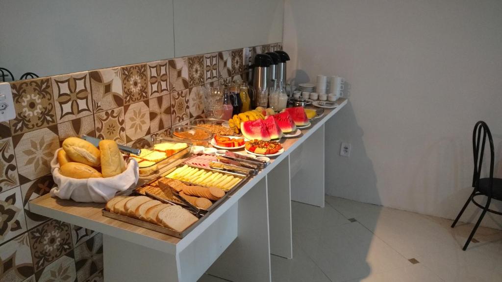 un buffet con pan y otros alimentos en una mesa en Lotus Hotel & Hostel, en Porto Alegre