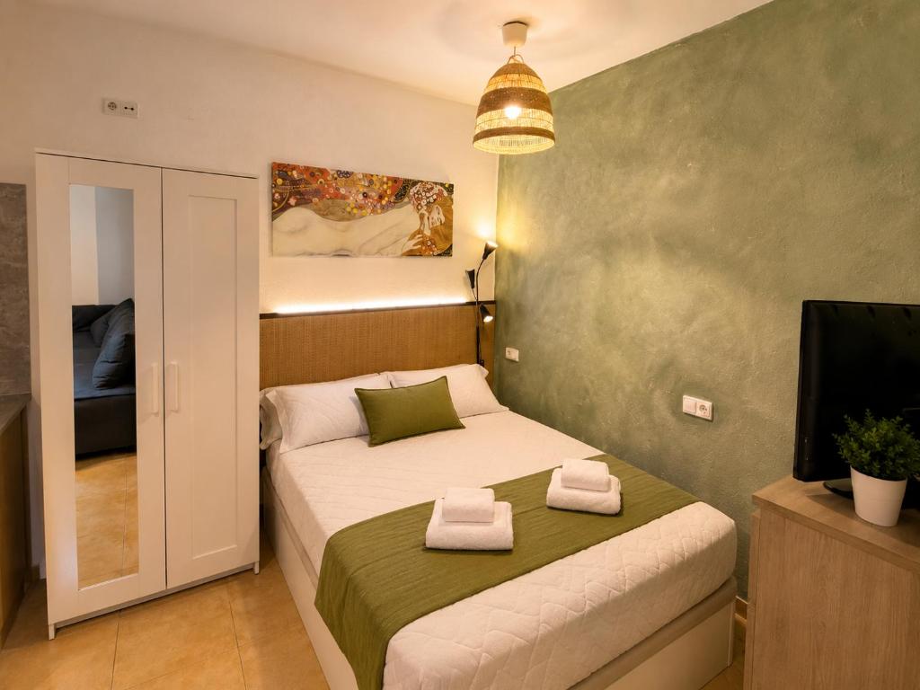 a small bedroom with a bed and a television at Lupe Mediterranean Loft,150m from the Beach Blanes Center in Blanes