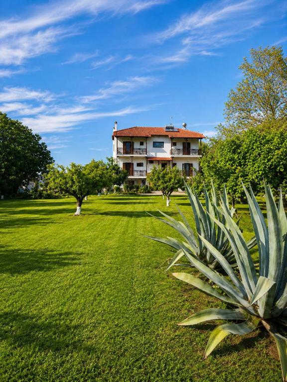 a large house in the middle of a green field at Pilgrimos Apartments in Ierissos