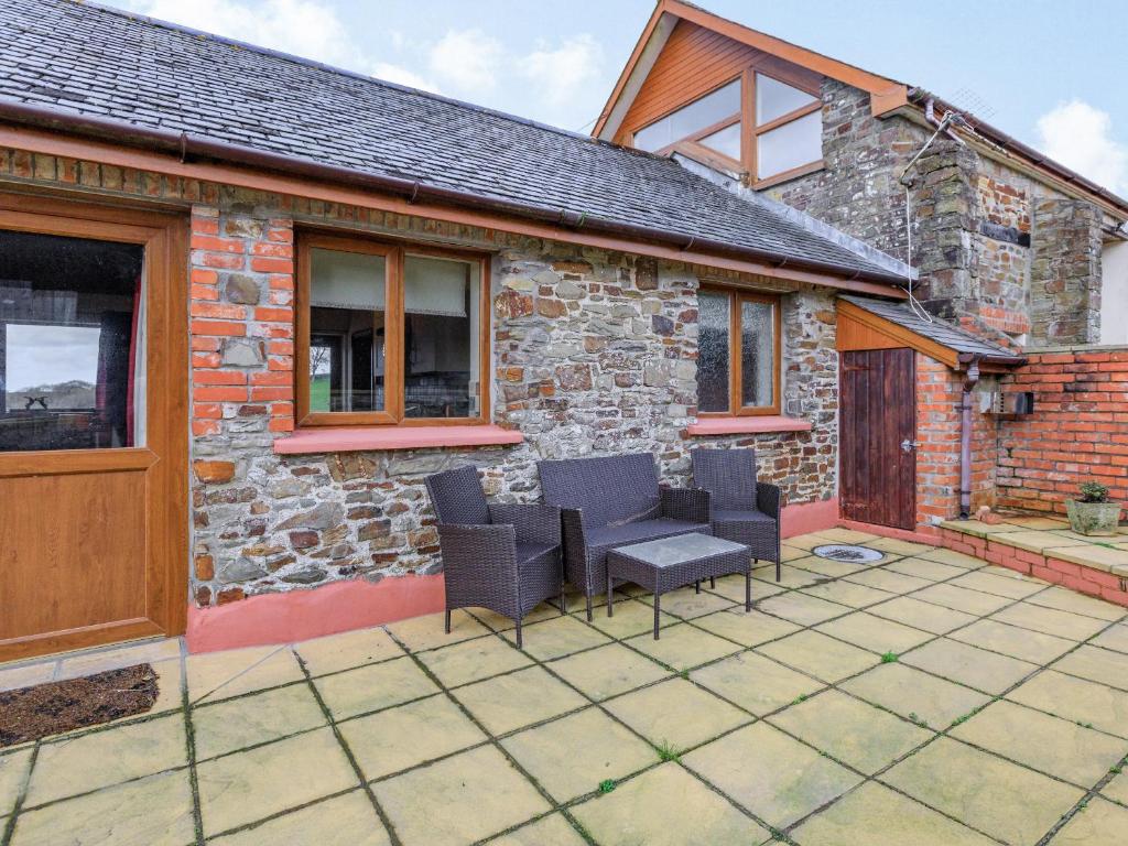 a patio of a house with chairs and a table at The Cartlinhay - Uk35756 in Bideford