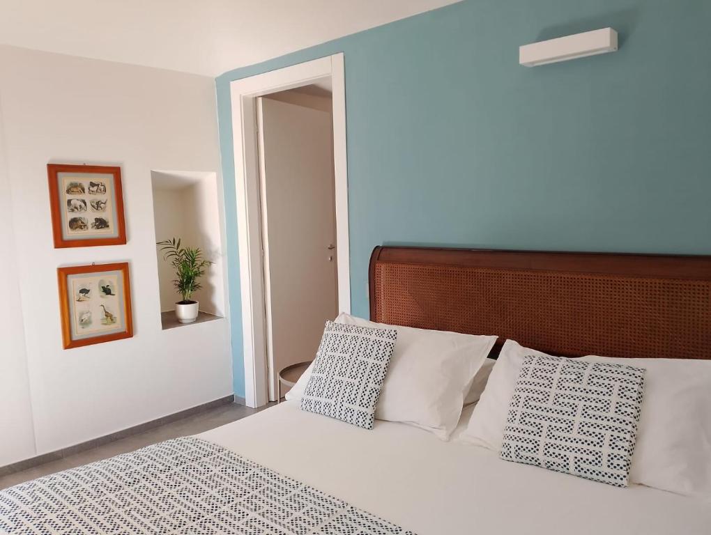 a bedroom with a bed with white sheets and pillows at Appartamento LaLieve - casaDELRESTO in Gaiola