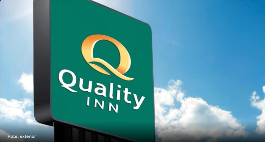 a sign for a qualifiability inn with clouds in the background at Quality Inn Petoskey in Petoskey