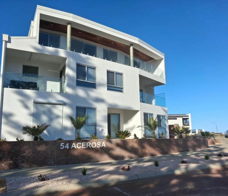 a white building with trees in front of it at Coastal Calm Seascapes unit 2 in Falcon