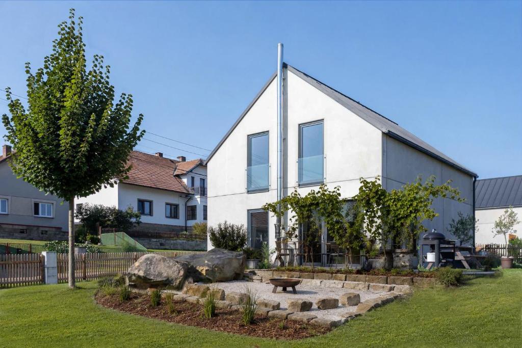 a white house with a bench in front of it at Domek u ráje in Bystřice