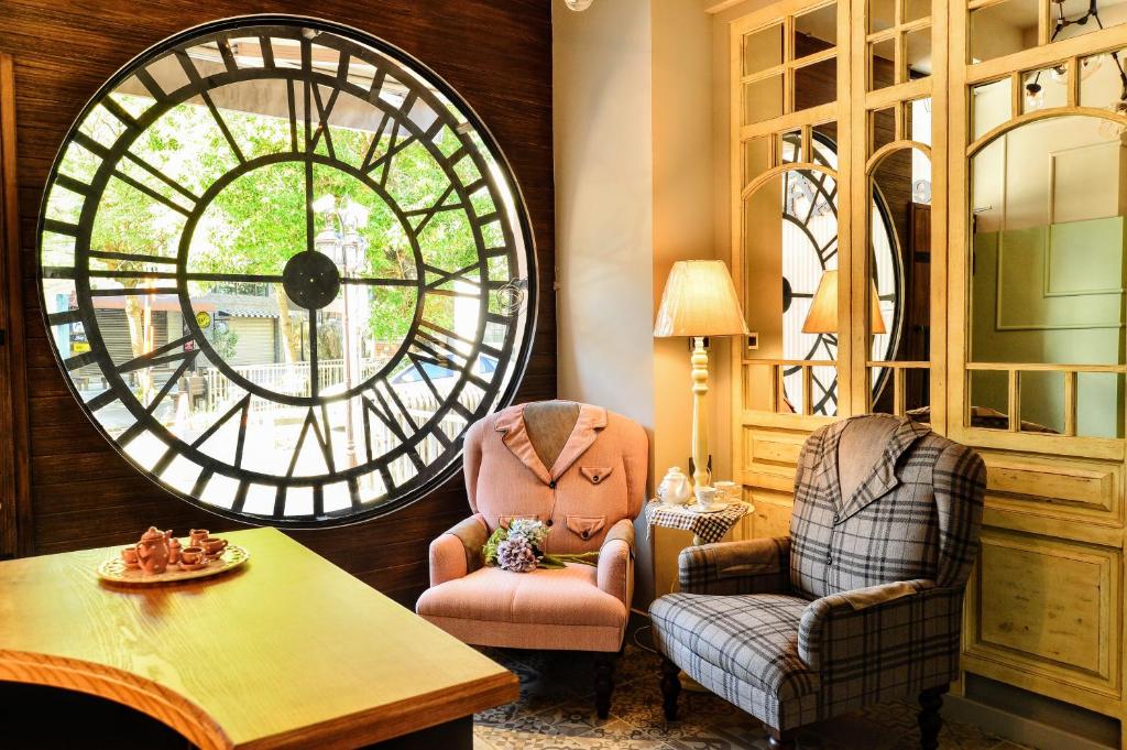 a room with a large clock and two chairs at Cheese Bon in Hualien City