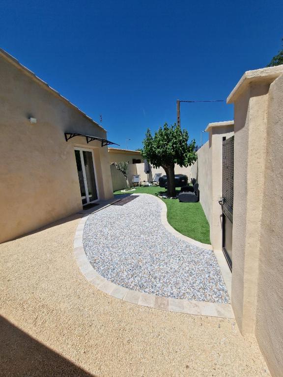 a walkway in front of a house with a tree at L'escale Provençale in Pierrelatte