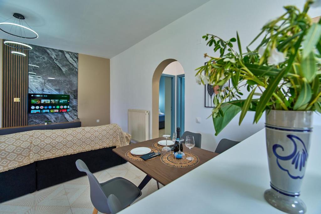 a living room with a table and a vase with a plant at Villa Escapes By The Beach in Sidari