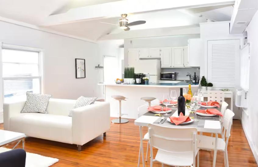 a white living room with a white couch and a table at Downtown Suite #4 - Wharf View in Newport