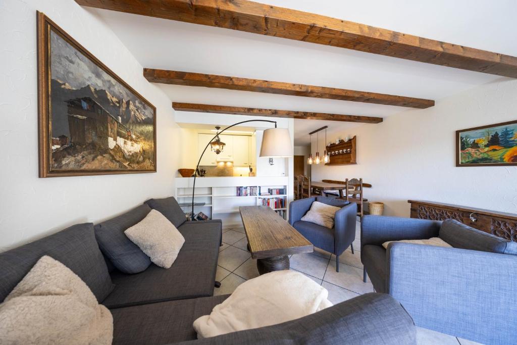a living room with two couches and a table at Alpenblick-Apartment mit Pool & Sauna in St. Moritz