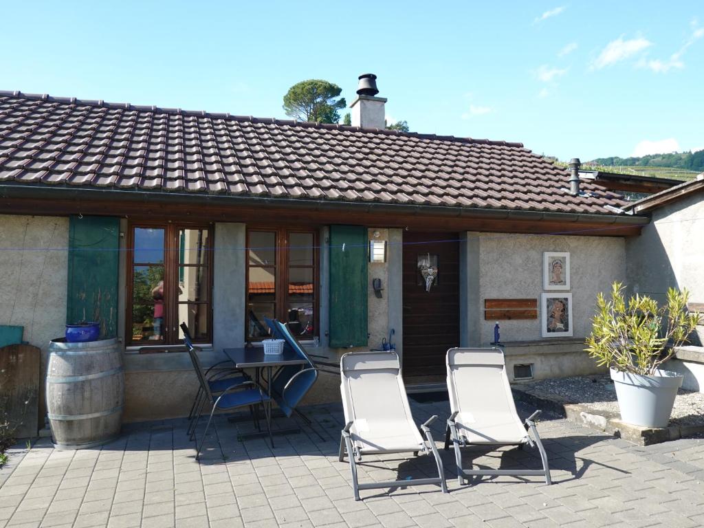 two chairs and a table in front of a house at "Les Échalas" Charmante maison au coeur du Lavaux, Cully in Cully