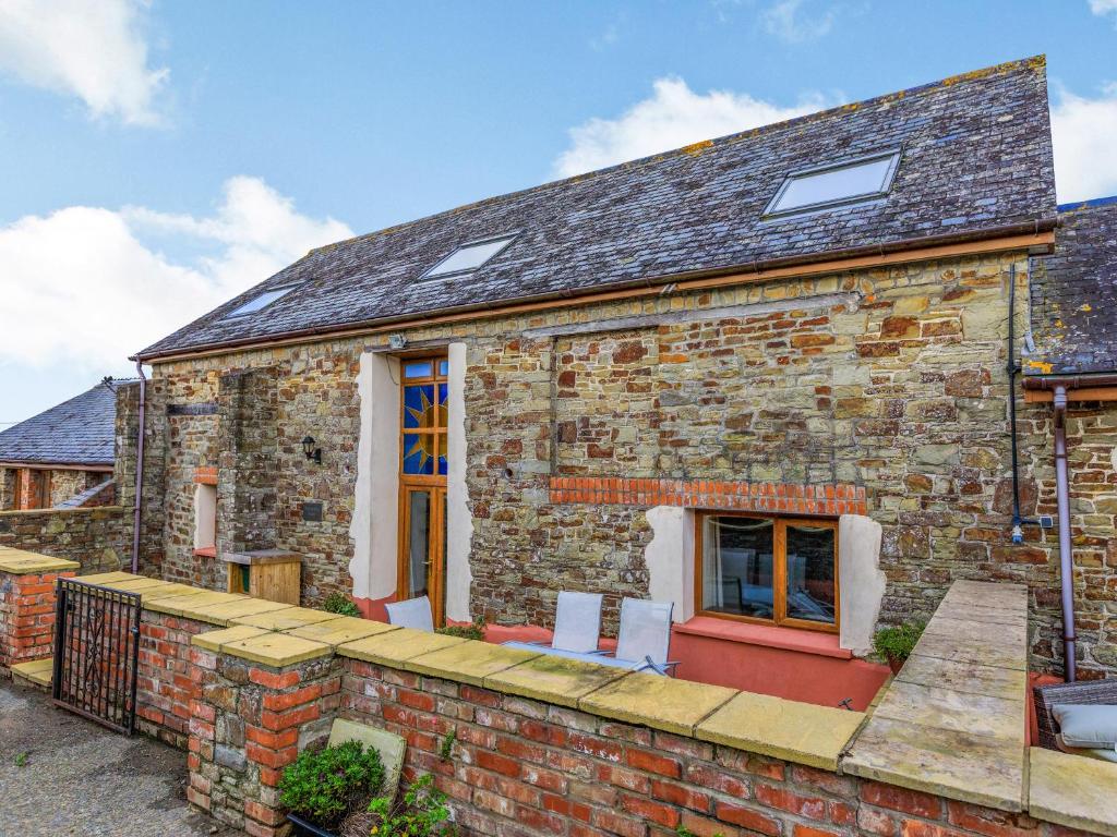 an old brick house with a red door at The Threshing Barn - Uk35754 in Bideford