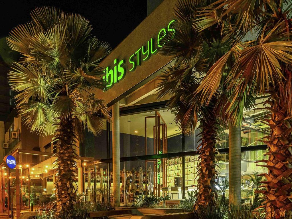 a store front with palm trees in front of it at ibis Styles Porto Alegre Moinhos de Vento in Porto Alegre